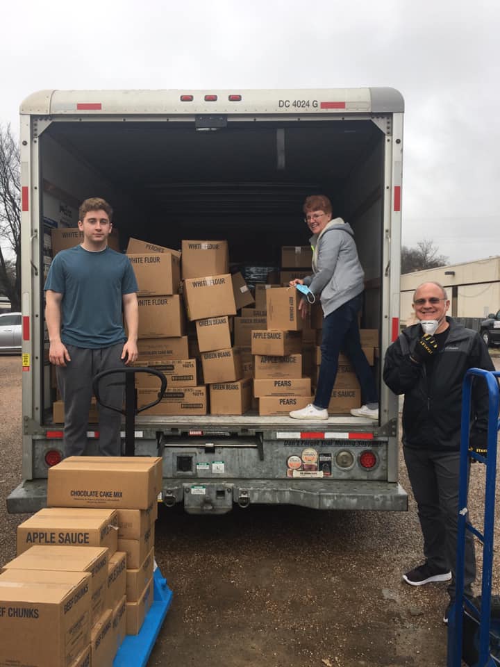 Volunteers unloading food donations from delivery truck